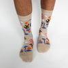 Beige socks with colorful abstract designs worn by a person on a white background