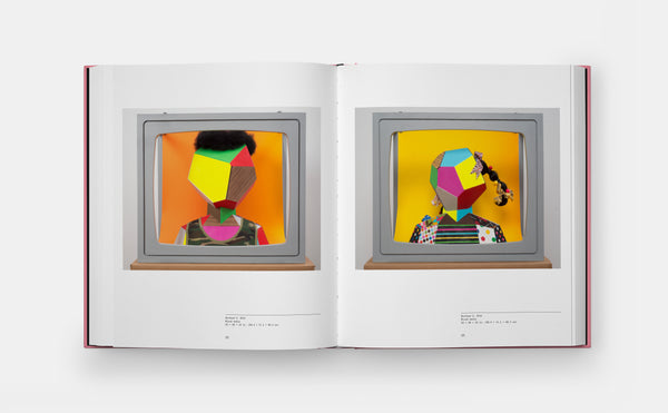 Open book displaying two colorful illustrations of abstract faces on a white background