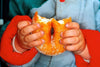 a photograph of a pair of hands folding a very large doughnut