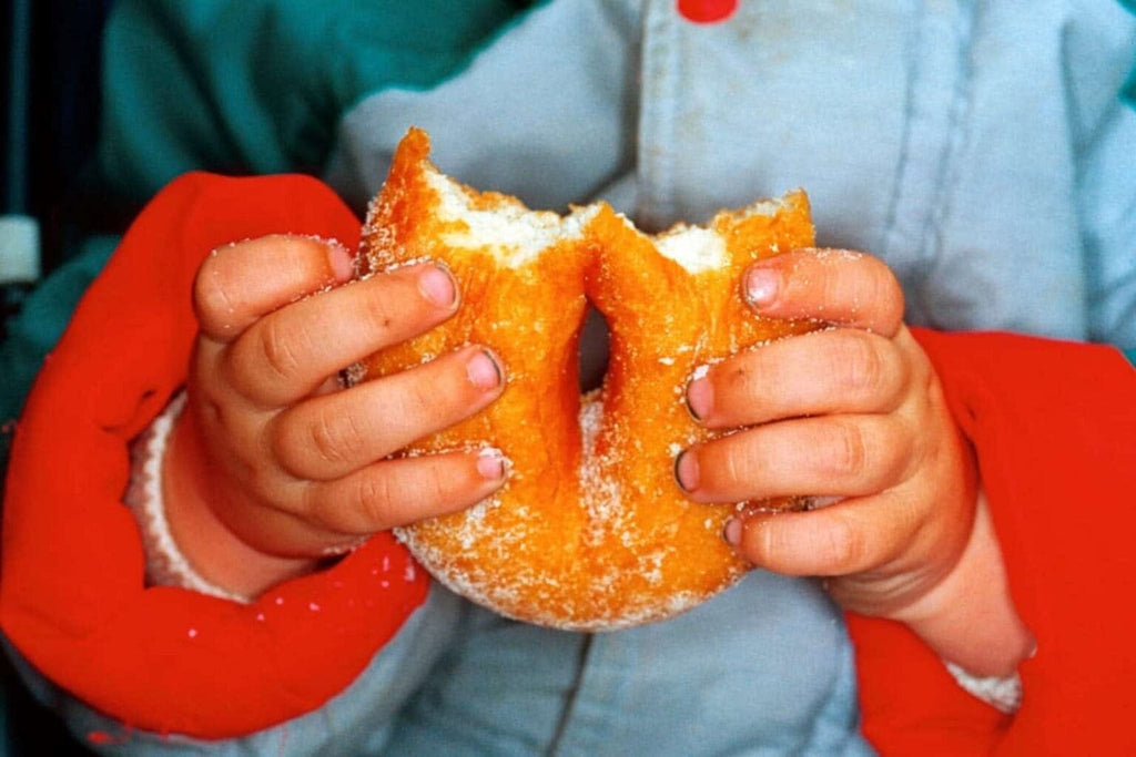 a photograph of a pair of hands folding a very large doughnut